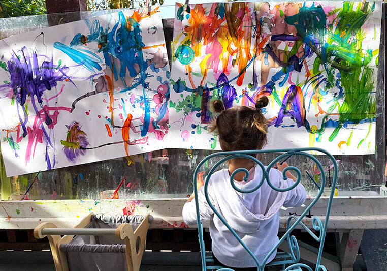 Parent Toddler Program Toddler painting in front of a large canvas